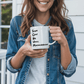 a woman holding a white coffee mug with the words super cool music on it