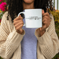 a woman holding a coffee mug with a quote on it