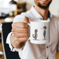 a man holding a coffee mug with a cat and dog on it