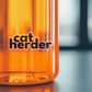 a close up of a cat herder jar with a cat sticker on it