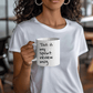 a woman holding a coffee mug with a message on it