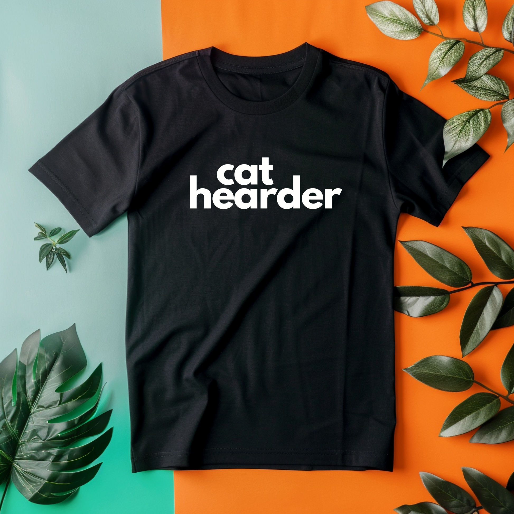 a black cat header t - shirt sitting on top of a green and orange