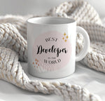 a white coffee mug sitting on top of a white blanket