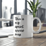 a white coffee mug sitting on top of a wooden table