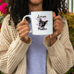 a woman holding a coffee mug with a dog on it