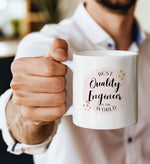 a man is holding a coffee mug with the words quality engineer on it