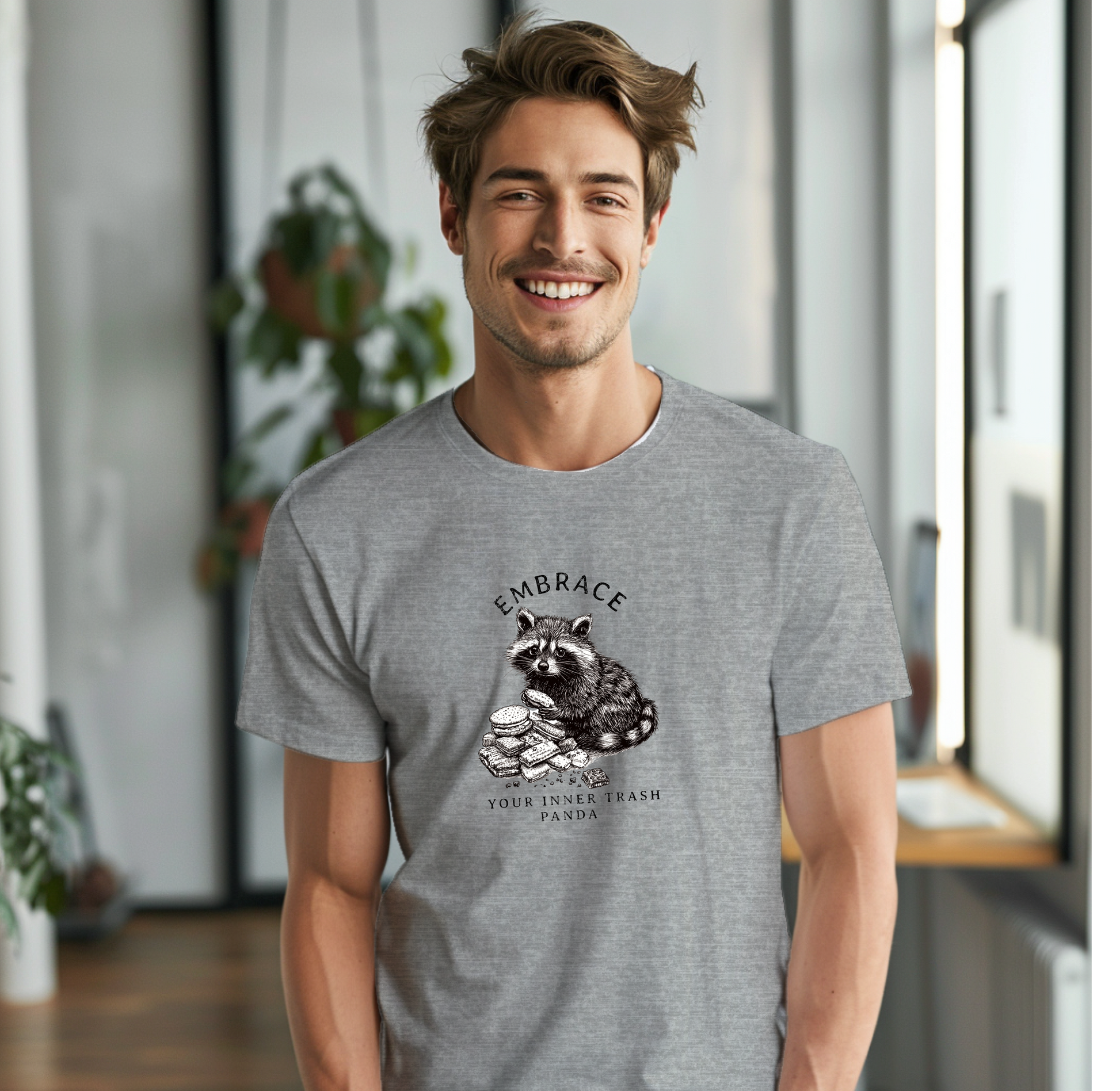 a smiling man wearing a gray shirt with a raccoon on it