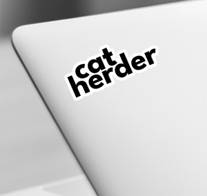 a catherder sticker on a laptop keyboard