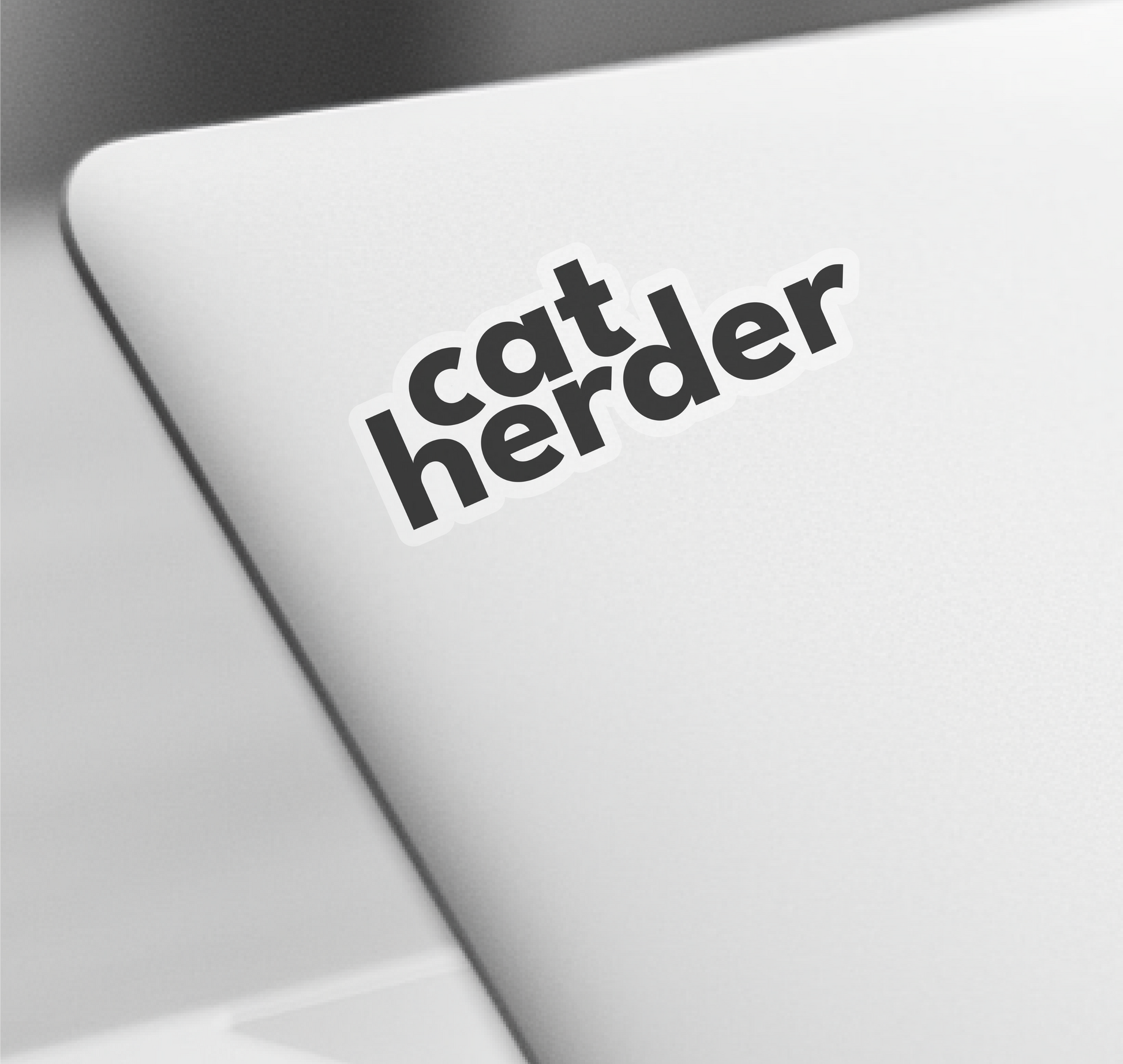 a catherder sticker on the keyboard of a laptop