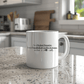 a white coffee mug sitting on top of a kitchen counter