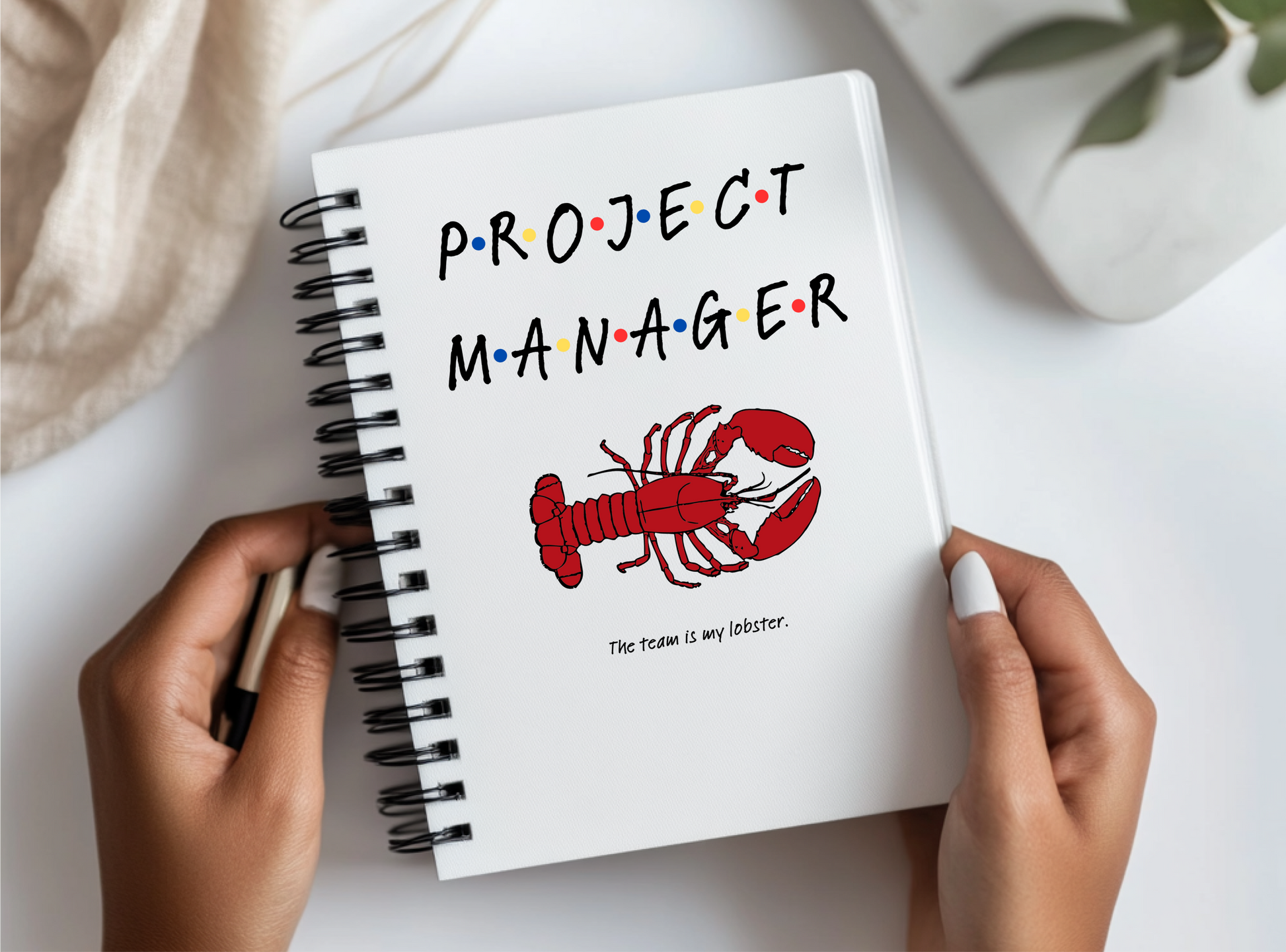 a person holding a notebook with a picture of a lobster on it