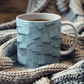 a cup of tea is sitting on a blanket